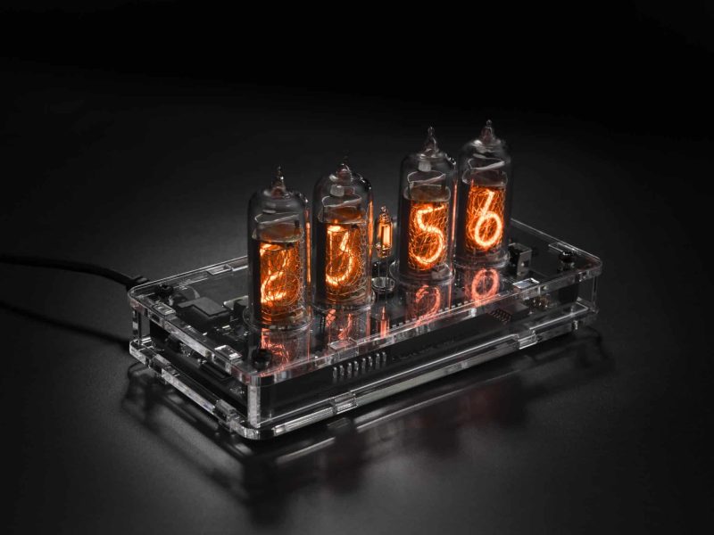 IN-14 four-tube Nixie clock in a transparent acrylic case, viewed from above at an angle.