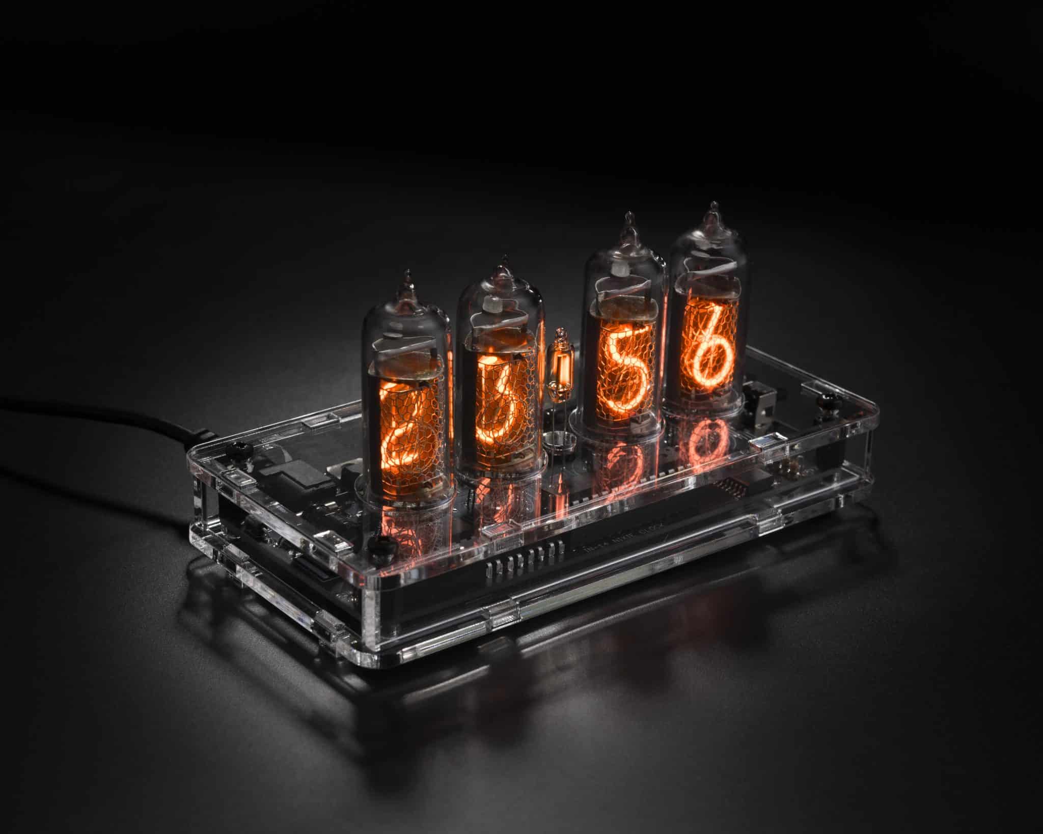 IN-14 four-tube Nixie clock in a transparent acrylic case, viewed from above at an angle.