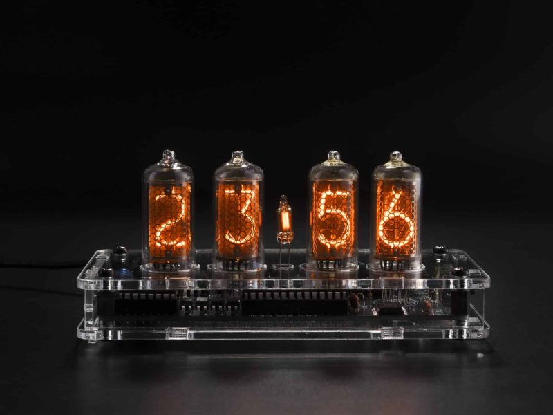 Front view of a four-tube IN-8-2 Nixie clock in a transparent acrylic case with the circuit board visible.