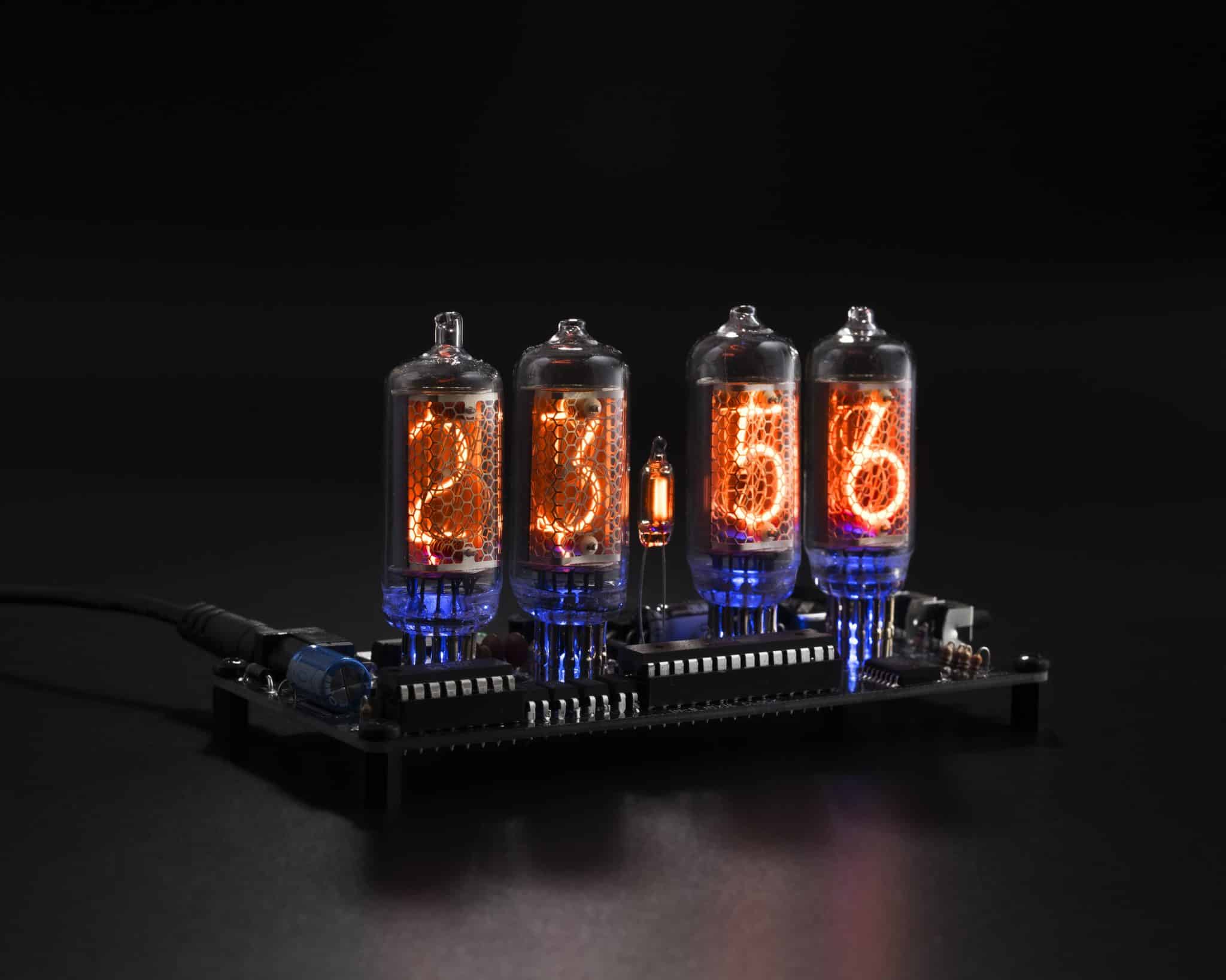 Angled view of four illuminated IN-8 Nixie tubes with blue backlighting on the clock board.