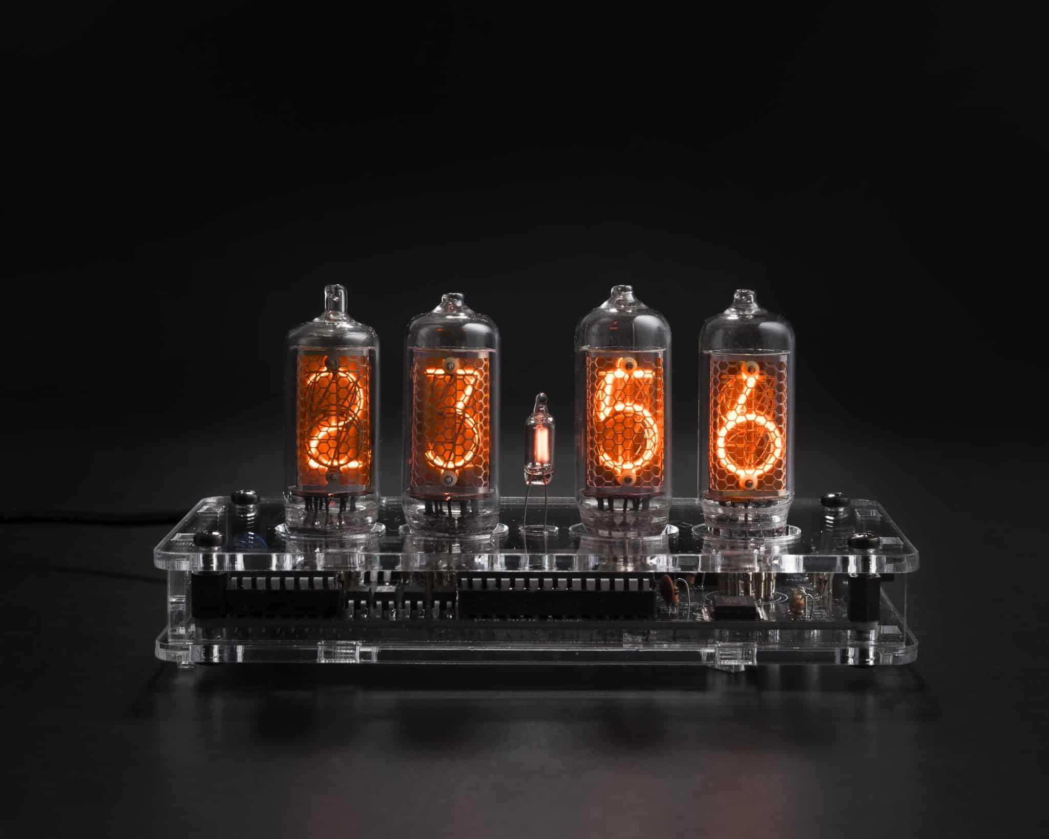 Front view of four glowing IN-8 Nixie tubes in a transparent acrylic clock case.