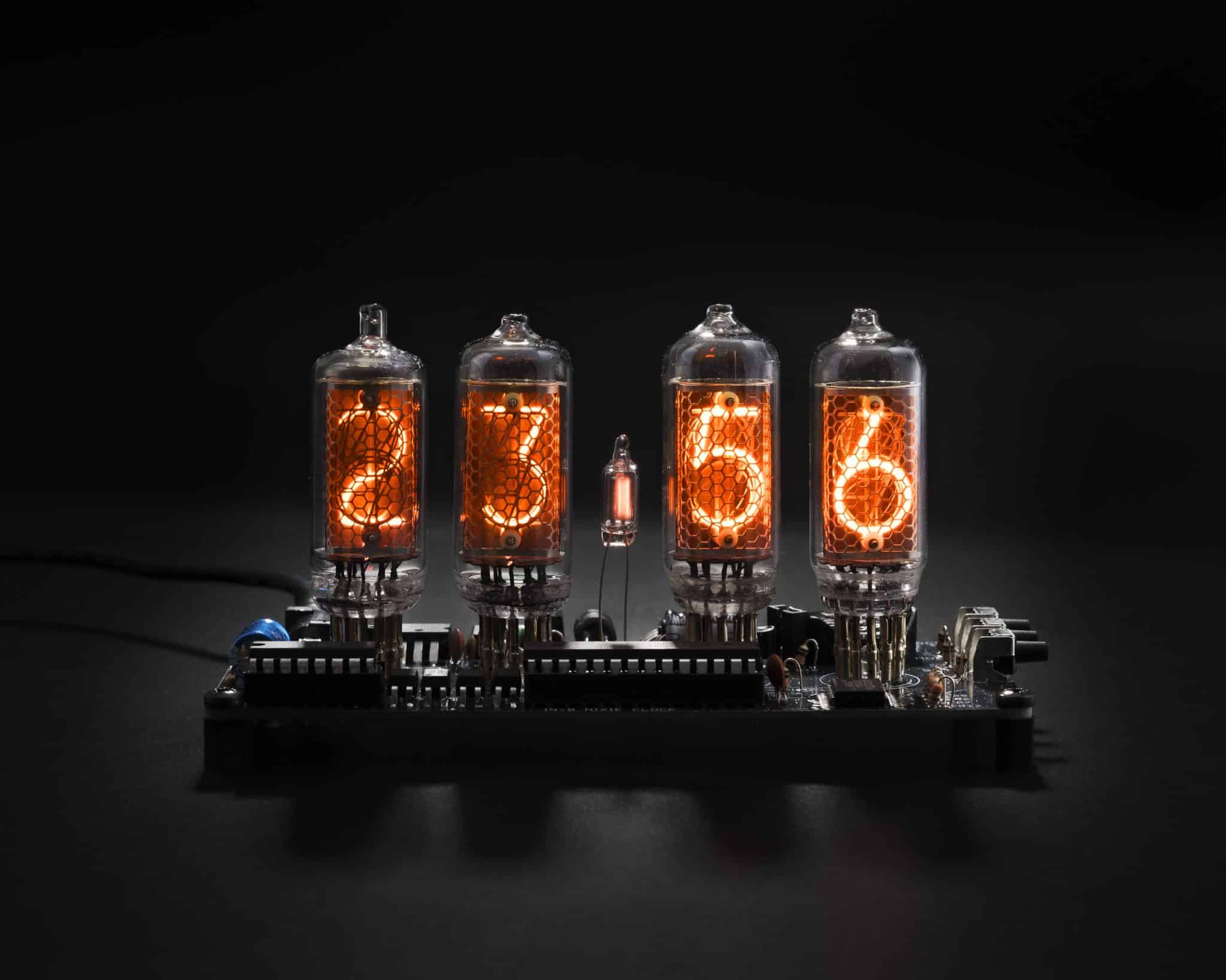 Front view of four orange IN-8 Nixie digits on an exposed clock circuit board.